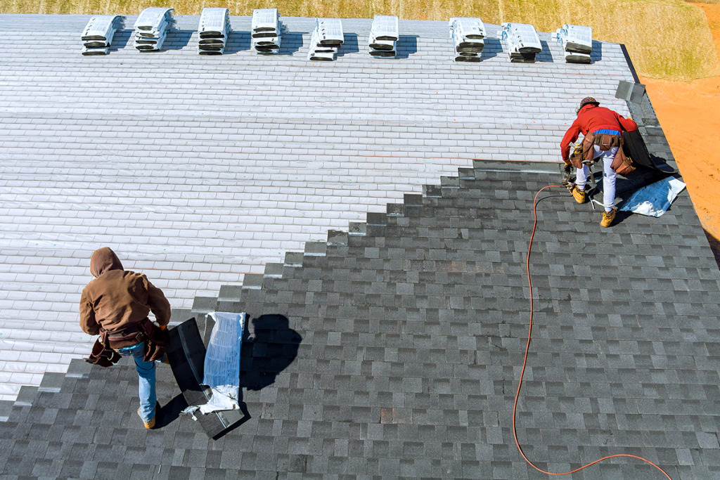 Two Roofing Contractors Reroofing a House