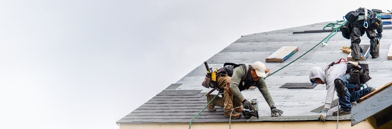 Men shingling roof