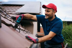 professional roofer inspecting shingles and flashing to prevent roof leaks before storm season