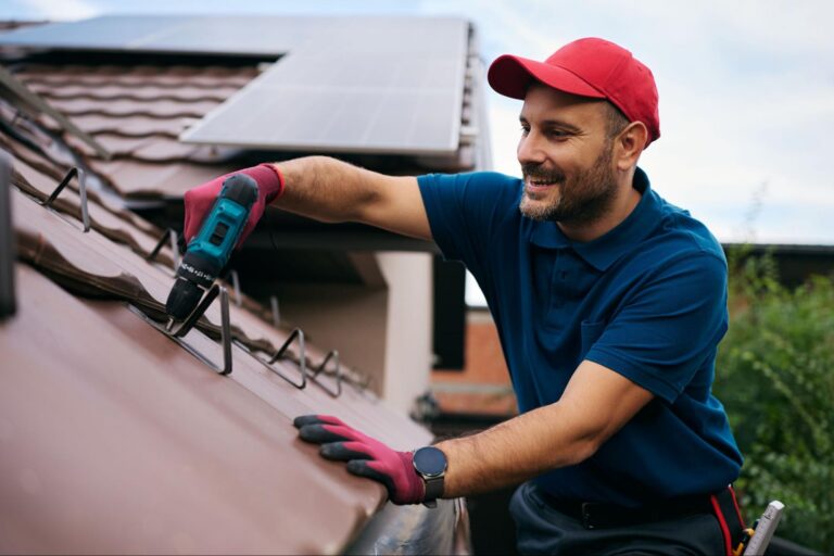 professional roofer inspecting shingles and flashing to prevent roof leaks before storm season